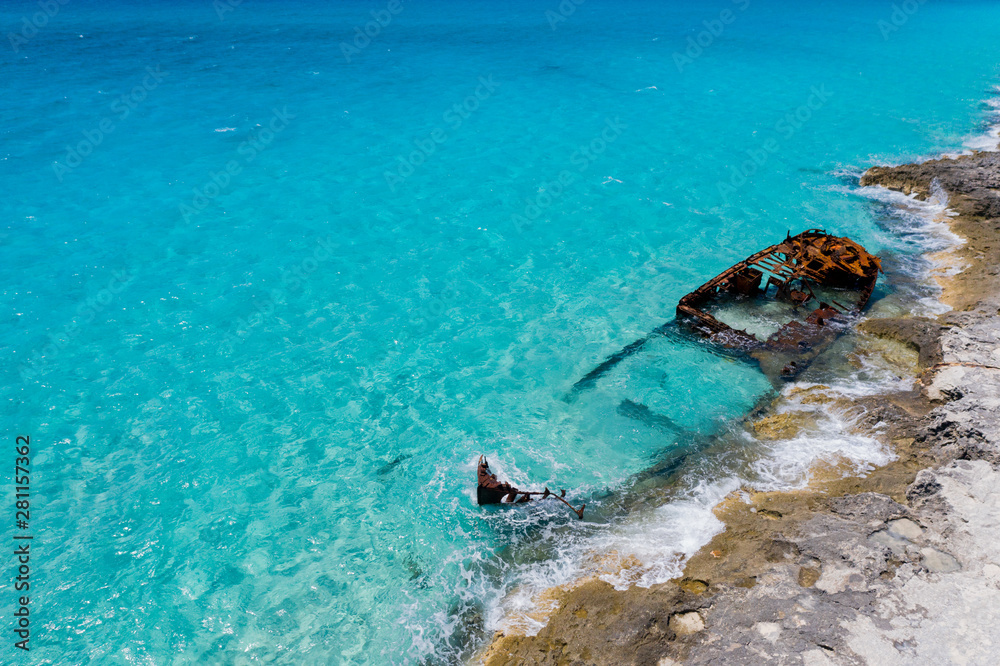 Shipwreck near the rocky coast in turquoise water
